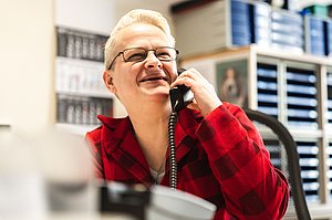 Frau hält einen Telefonhörer in der Hand.