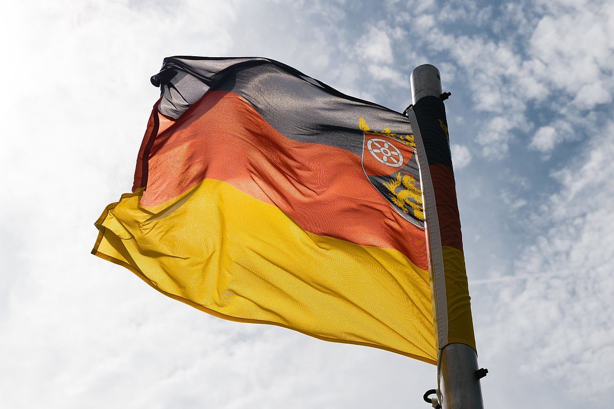 Eine Flagge von Rheinland-Pfalz weht an einem Fahnenmast.